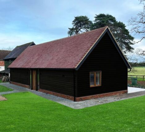 Annexe annexe exterior featuring charred wood cladding and clay tile roof.