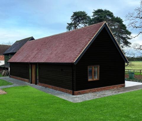 Annexe annexe exterior featuring charred wood cladding and clay tile roof.