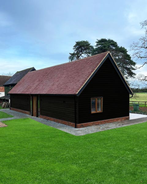 Annexe annexe exterior featuring charred wood cladding and clay tile roof.